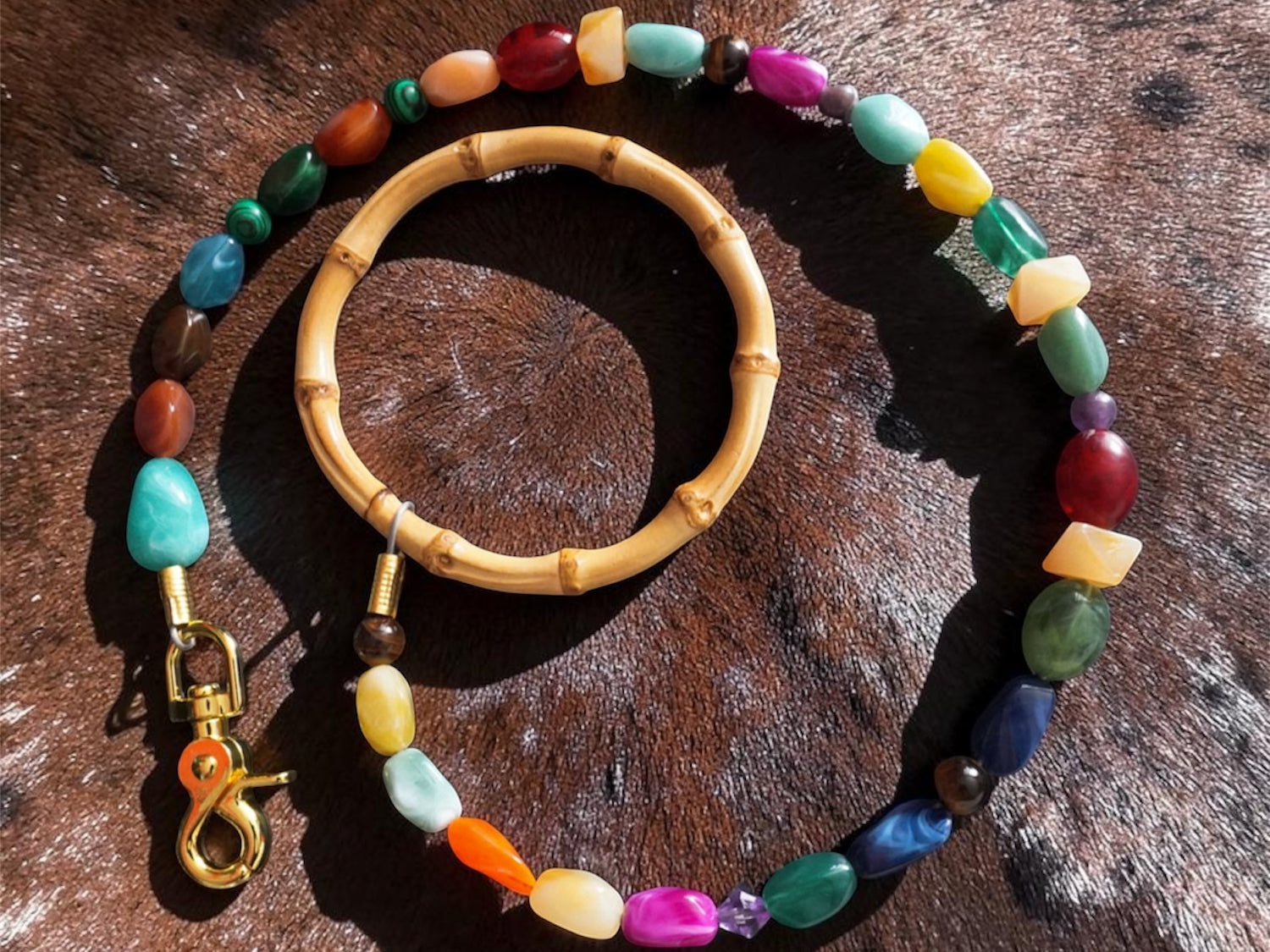 Colorful beaded leash with a wooden handle on a textured brown surface