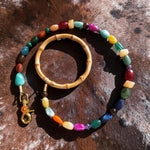 Colorful beaded leash with a wooden handle on a textured brown surface